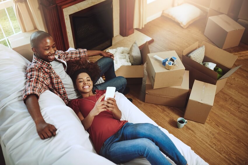We moved cards: couple resting on a couch while using a phone