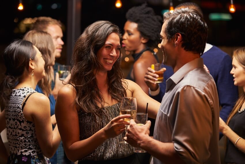 Stock the bar party: couple smiling at each other at a party