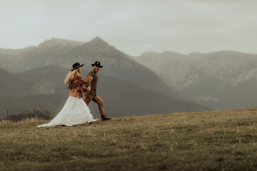 Elopement ideas: couple walking on top of a mountain