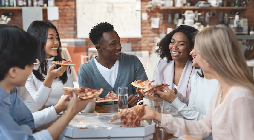 Workiversary: employees happily celebrating and eating pizza