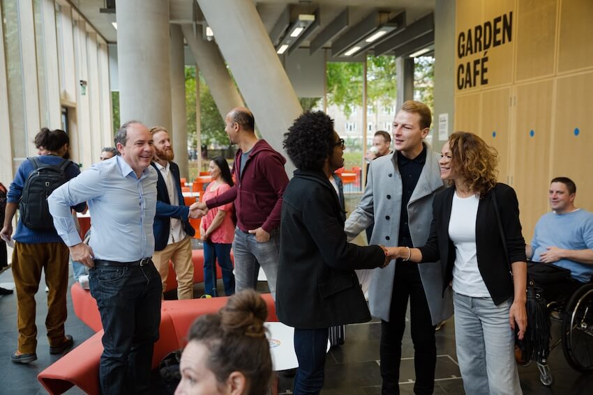 Meet and greet invitation: employees shaking hands