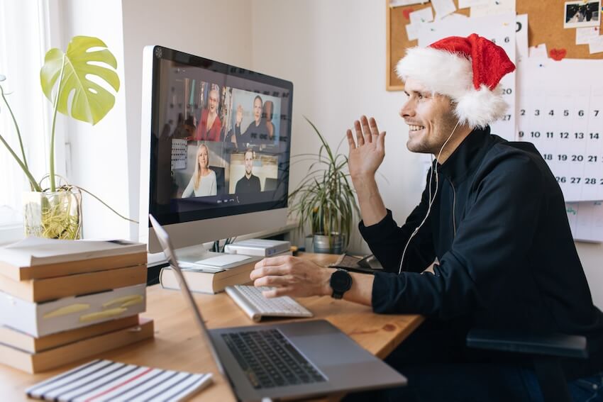 Work holiday party: entrepreneur having a video call with his colleagues