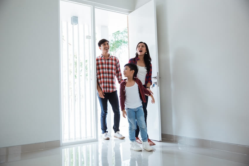 Family happily walking inside their new house