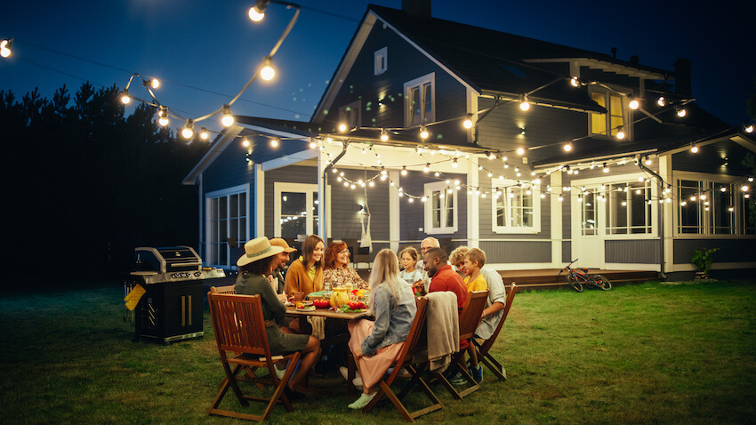 BBQ birthday party ideas for adults: family having dinner in their garden