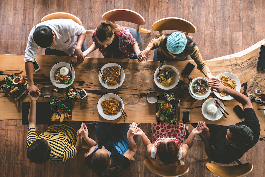 Easter invitations: family praying before eating