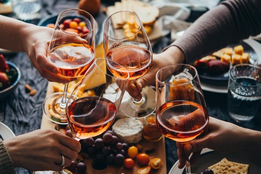 Four people clinking their wine glasses