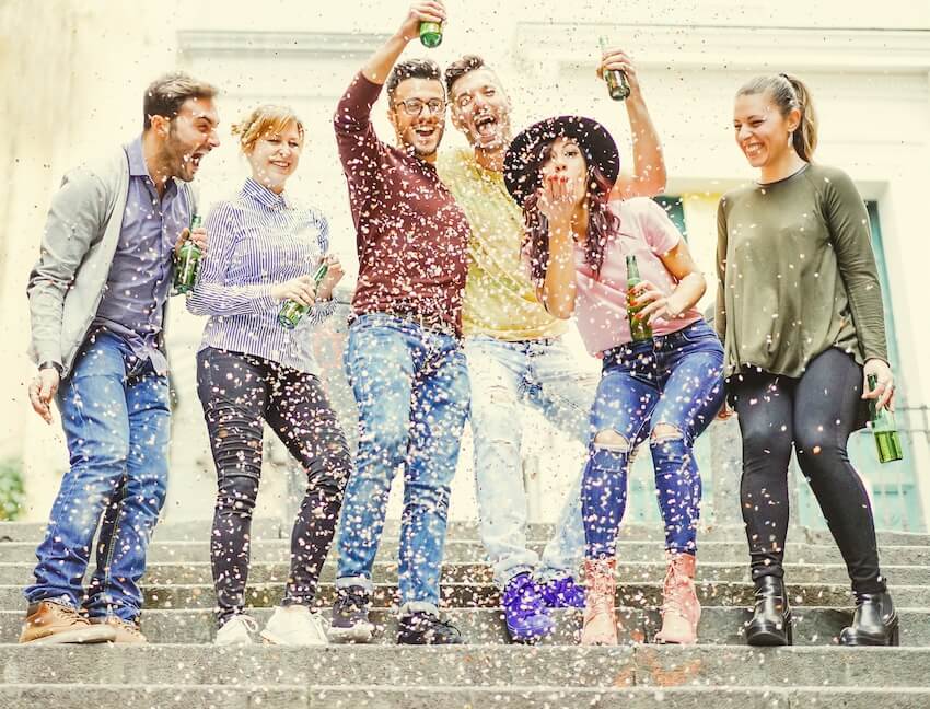 Friends laughing while confetti falls to the ground