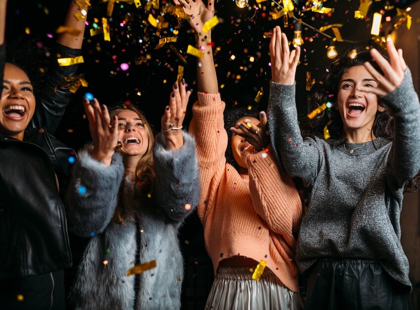 New Year's traditions: friends throwing confetti up in the air