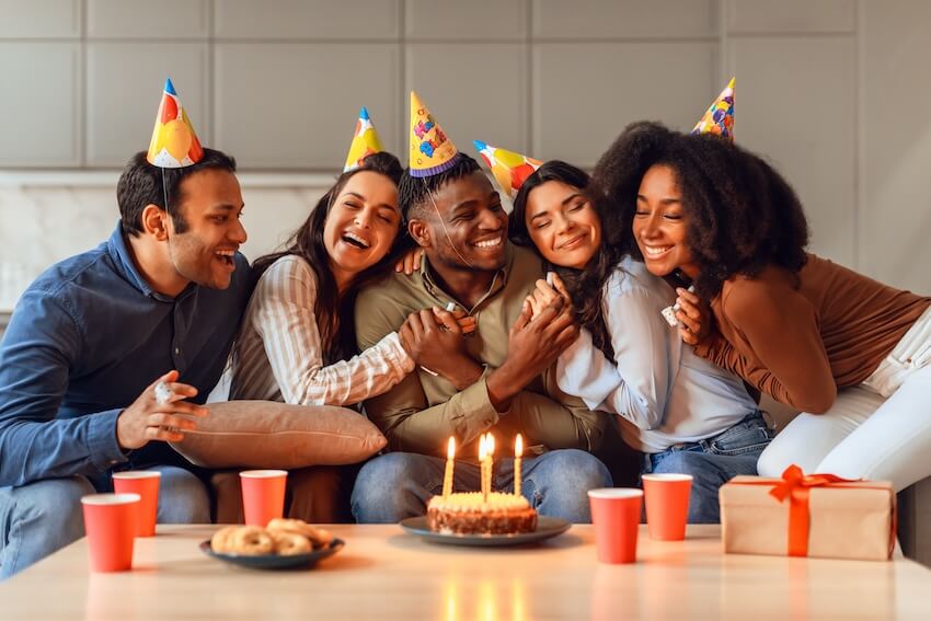 Happy birthday brother in law: family wearing party hats while hugging each other