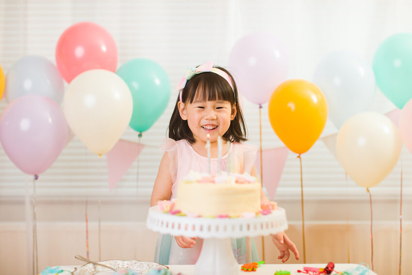 Girl happily looking at her birthday cake