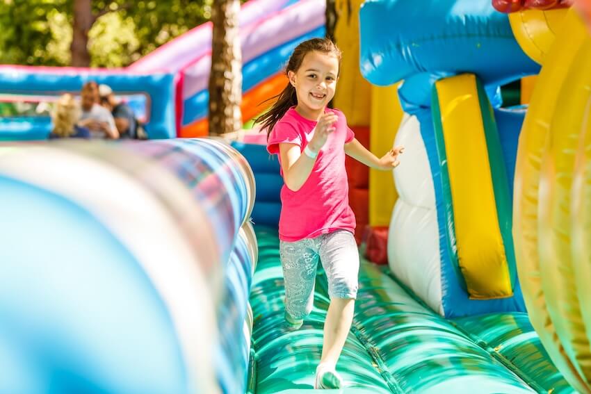 Girl running on an inflatable obstacle course