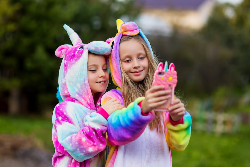 Girls wearing unicorn costumes and taking a groufie
