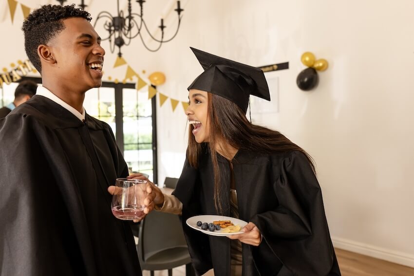 Graduation wishes for friend: graduates happily talking to each other