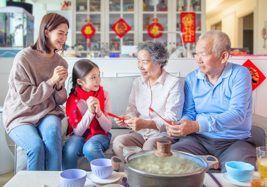 Chinese New Year phrases: grandparents giving red envelopes to their grandchild