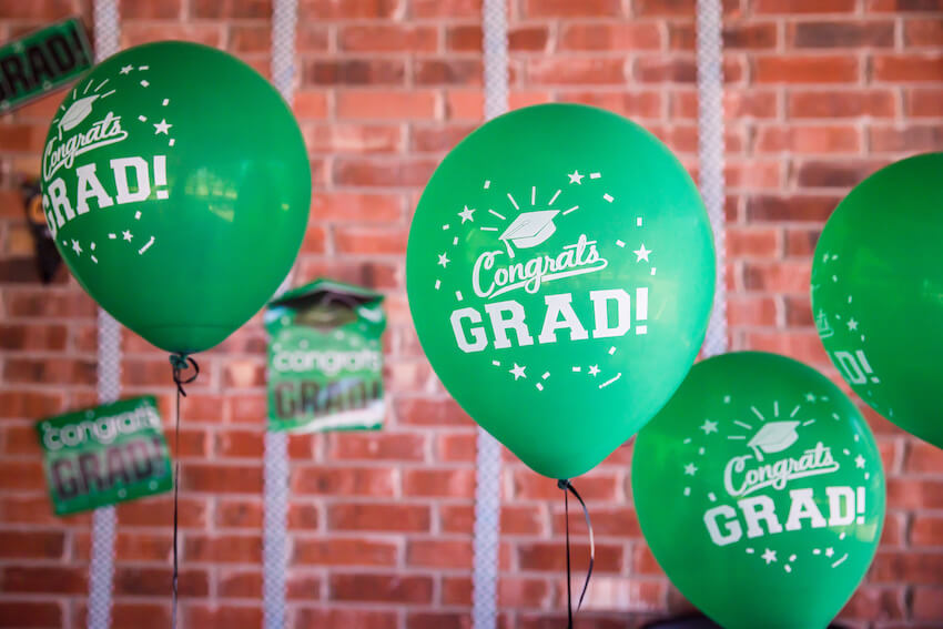 Graduation decoration ideas: green balloons with Congrats GRAD text on it