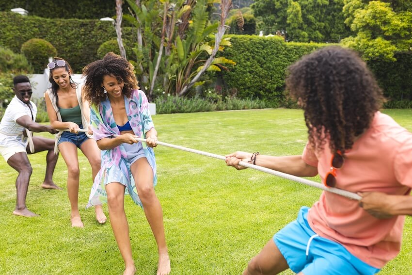 Field day games for adults: group of employees playing tug of war