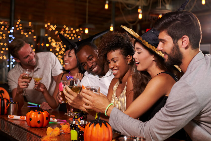 Halloween party invite wording: group of friends celebrating Halloween at a bar