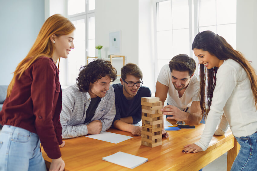 Adult game night: group of friends happily playing Jenga