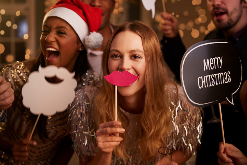 Group of friends holding Christmas themed masks