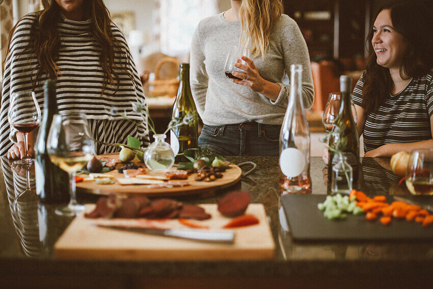 Adult game night: group of friends sharing a meal and drinking wine