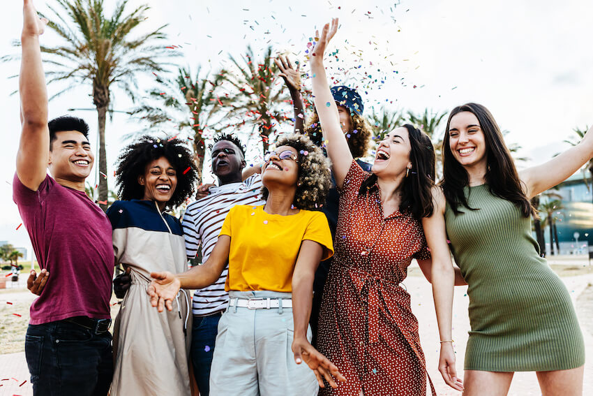 Party themes for adults: group of friends throwing confetti in the air