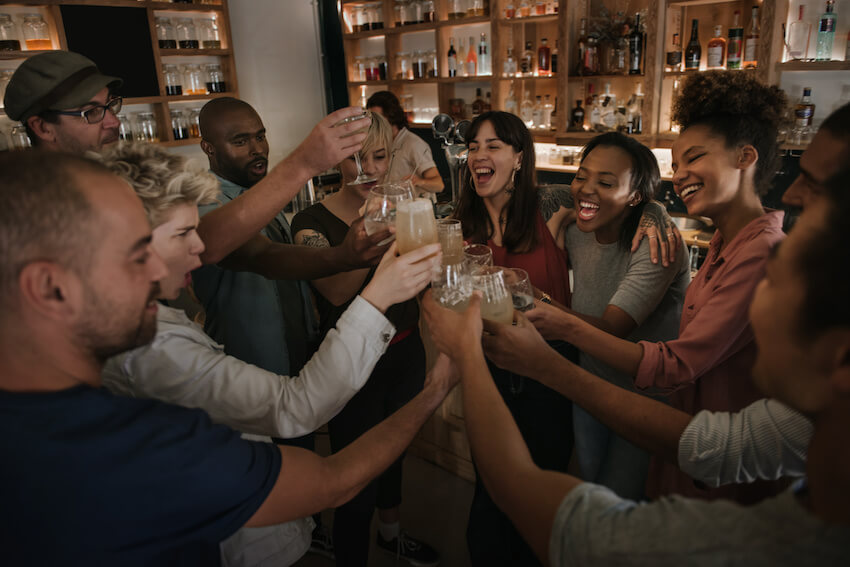 23rd birthday ideas: group of people happily having a toast
