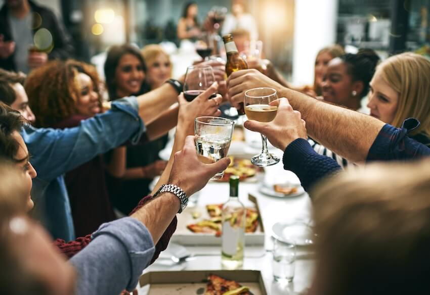 Dinner party invitations: group of people having a toast at a dinner party