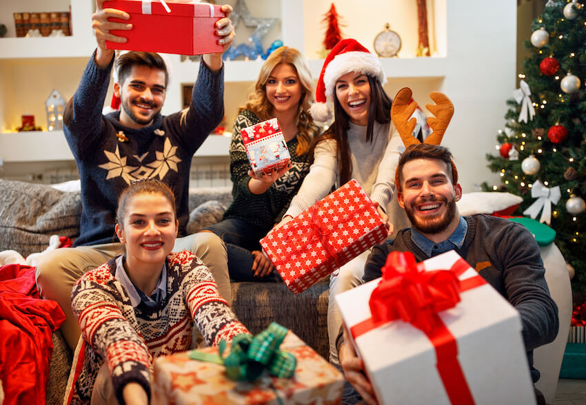 Group of people holding Christmas gifts