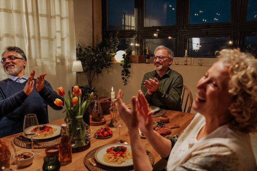 Group of seniors clapping their hands during dinner