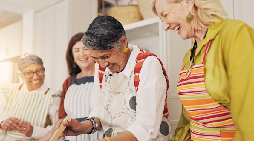 Nesting party: group of women happily cooking in a kitchen