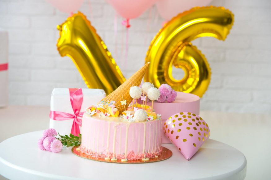  sweet 16 party ideas: Pink cake and number balloons on a table