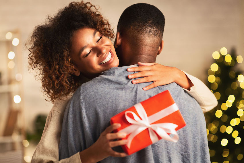 thank you card messages: woman holding a gift and hugging a man