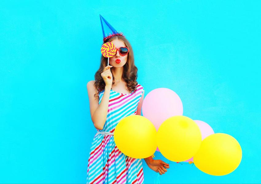 lady holding a balloon and lollipop