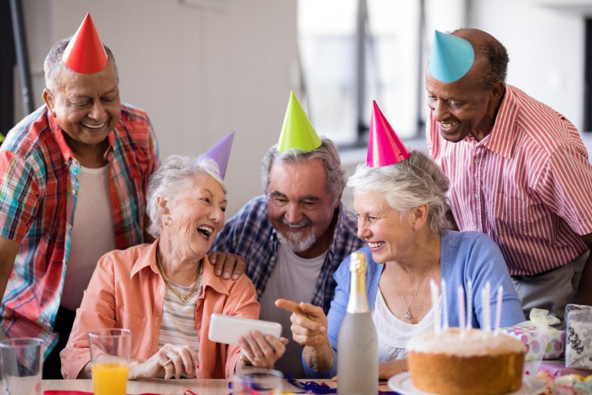 80th birthday invitations: five old people smiling and wearing party hats