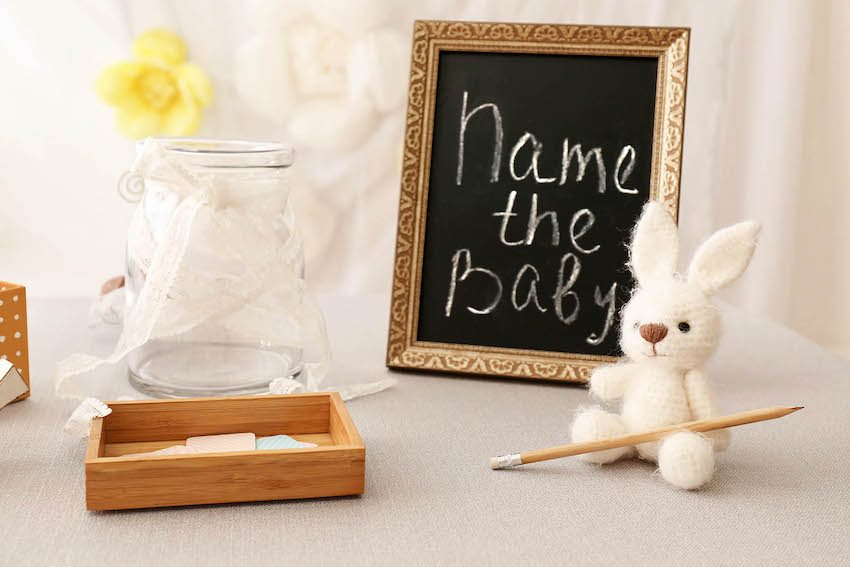 baby shower ideas for boys: Name the baby written on black frame with little rabbit