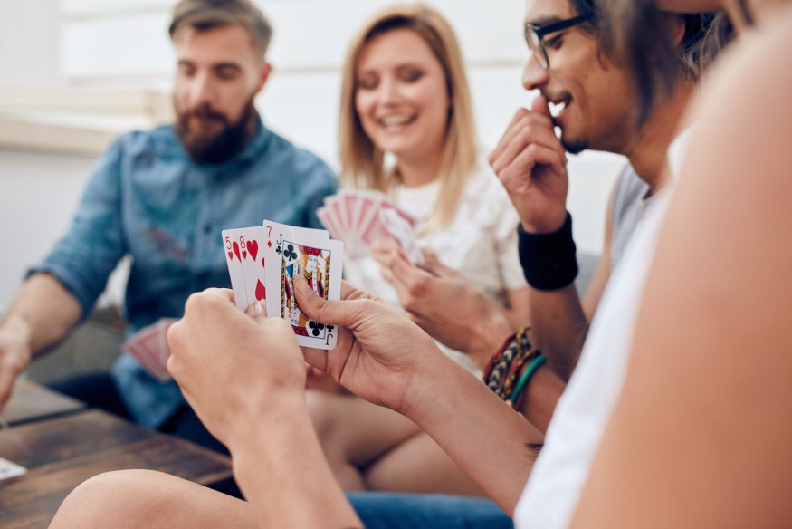 A group of friends sitting together playing cards