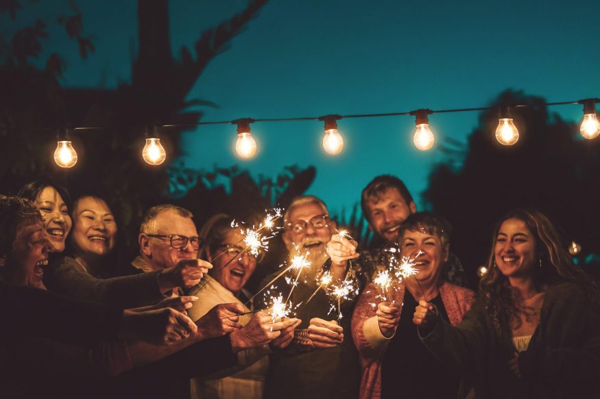 60th birthday party ideas: Friends and family smiling while holding sparklers