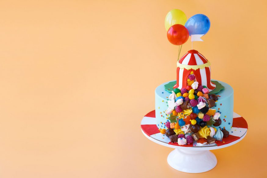 carnival theme party: Cake with circus decorations against an orange background