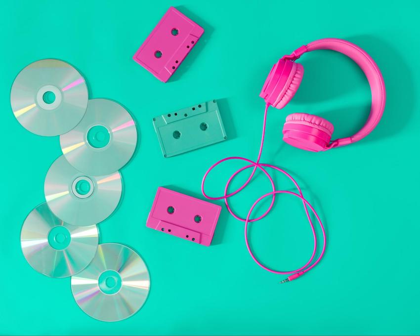 90s theme party: Pink headphones and audio cassettes with CDs