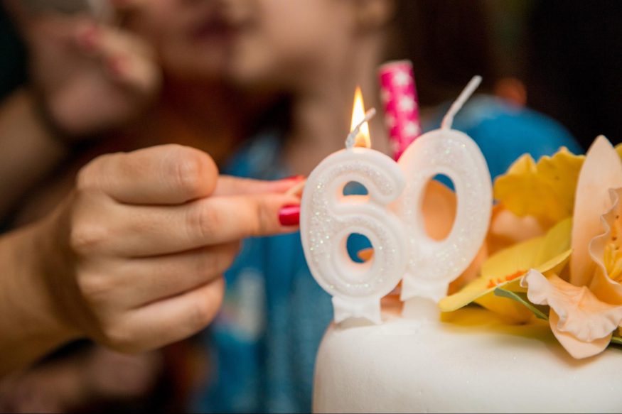 Woman lighting number 60 candles