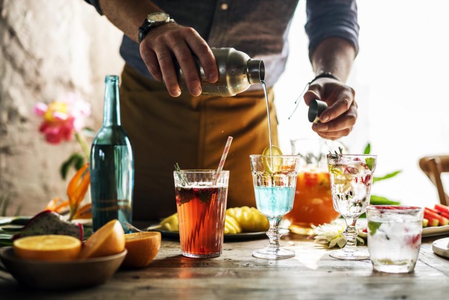 virtual happy hour: Man pouring a cocktail into a glass