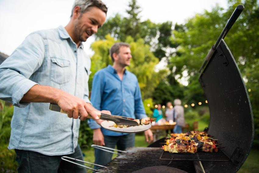 BBQ invitations: man getting a BBQ from the grill