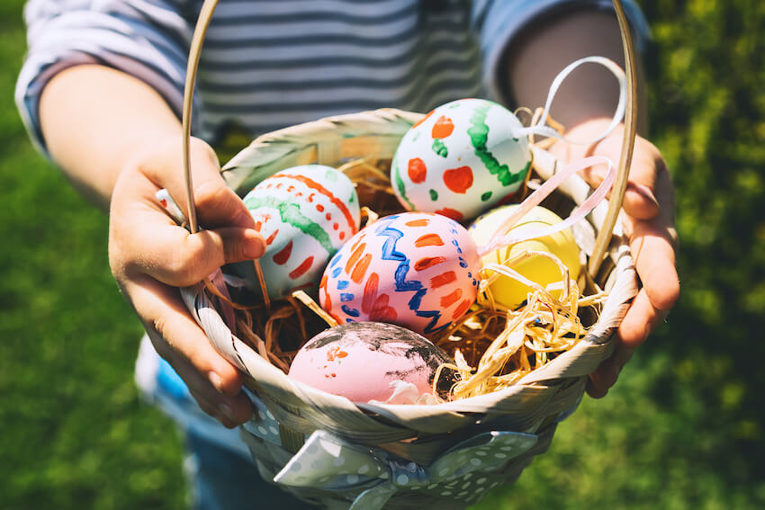 Easter egg ideas: kid holding a basket of Easter eggs
