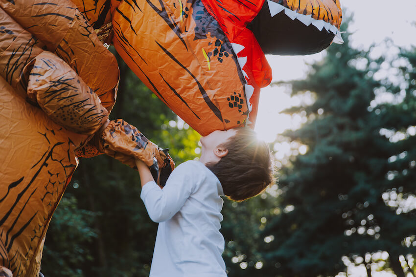 Dinosaur decorations: kid kissing an inflatable dinosaur suit