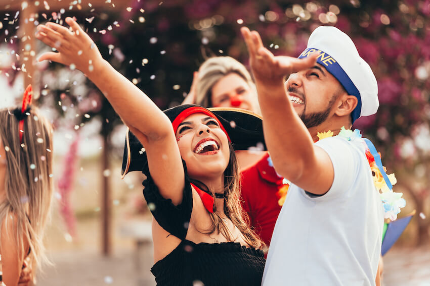 Costume party ideas: man and woman throwing confetti in the air