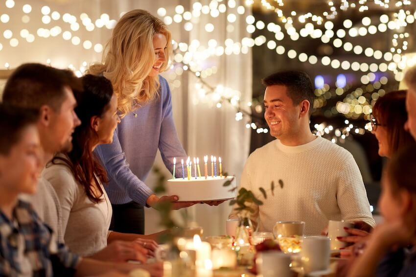 Happy 50th birthday wishes: man happily looking at his birthday cake