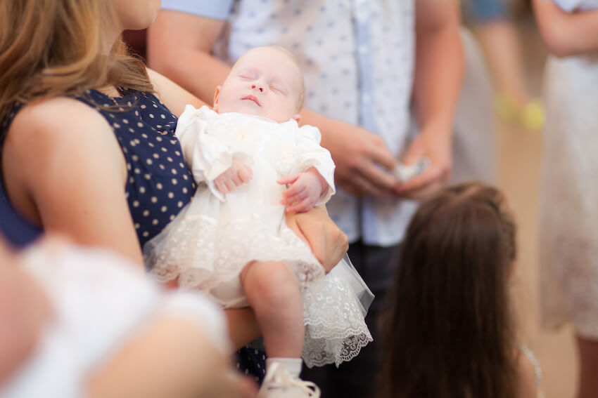 Baby's baptism: mother carrying her baby