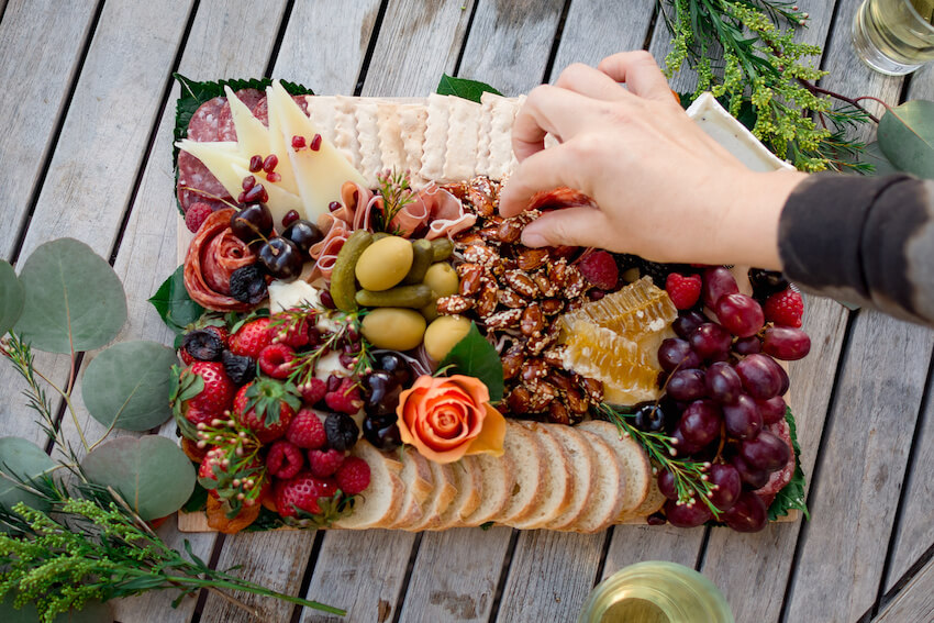 Farm themed birthday party: person getting food from a charcuterie board