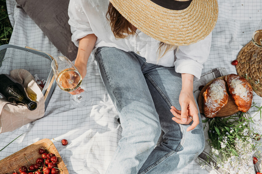 Aesthetic picnic: person holding a glass of wine