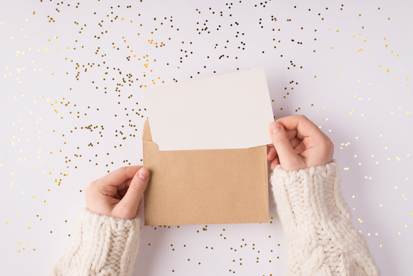 Person holding an envelope and a card